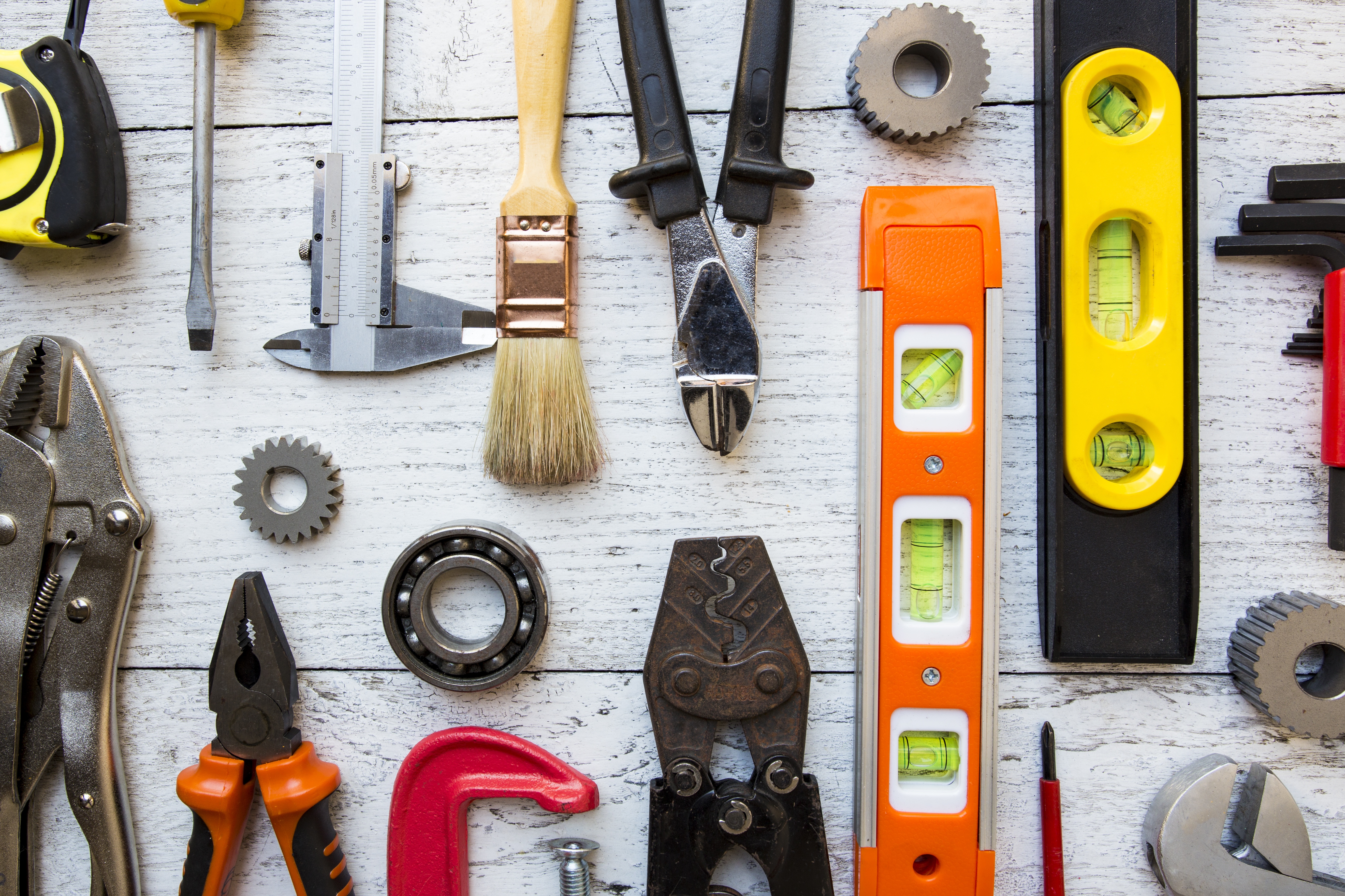 Various tools laid out in an orderly fashion on a white wooden tabletop