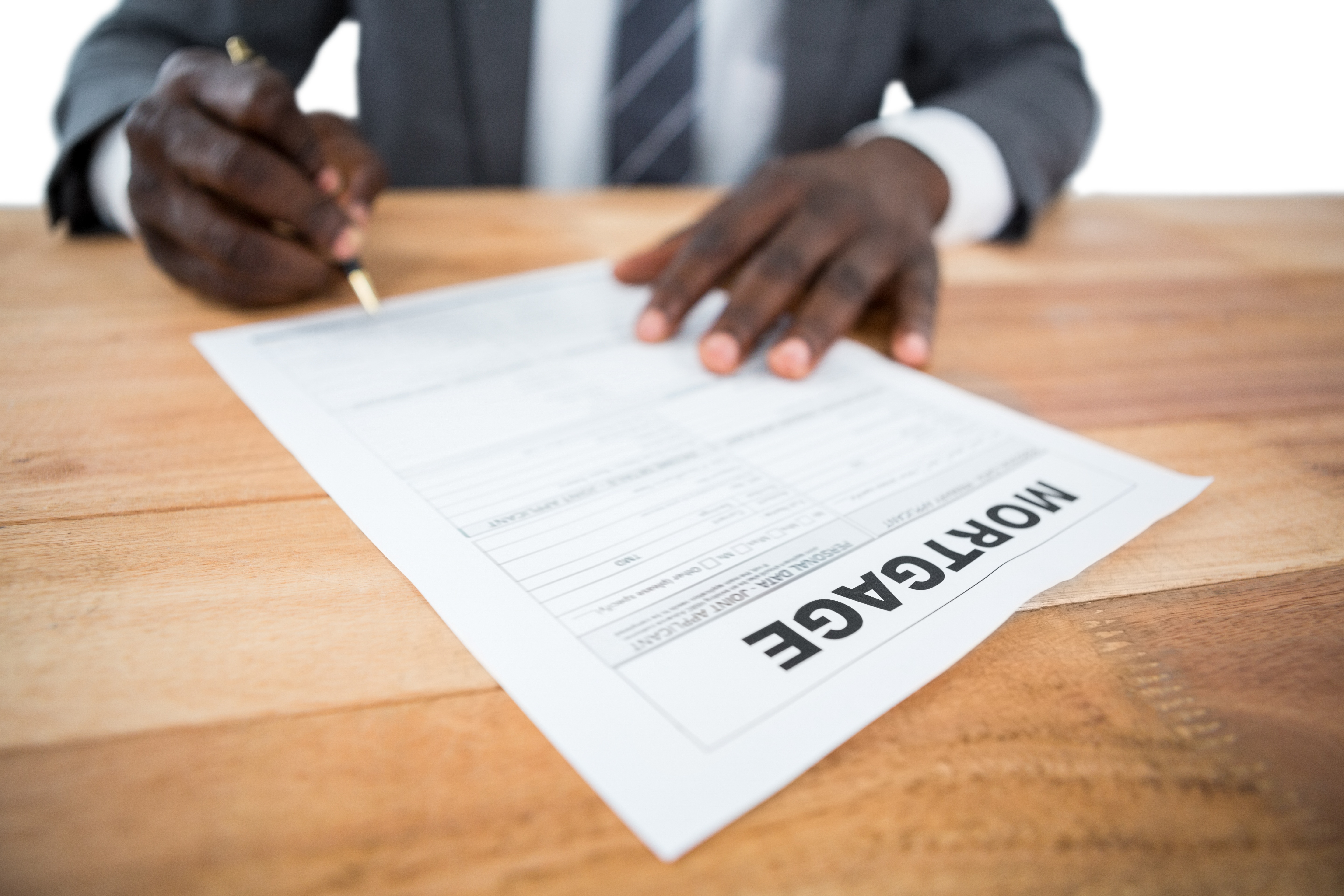 Man in suit signing mortgage application