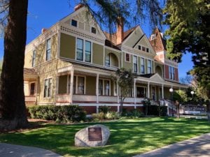 Colonia style house with large trees and beautifully manicured green lawn in historic downtown San Dimas